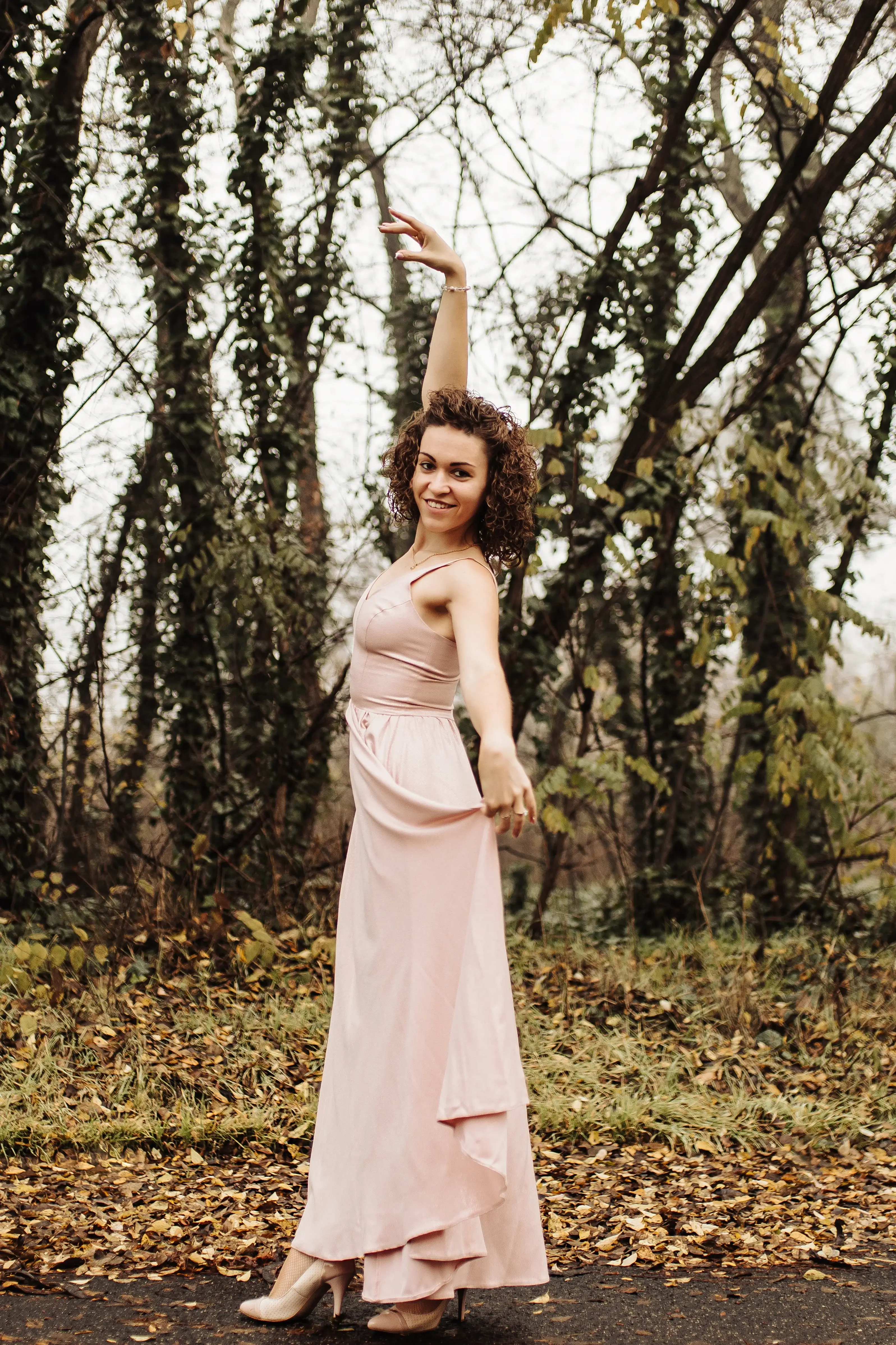 Varjuné Mikó Dóra az erdő mellett egy tánc pozíciót vesz fel